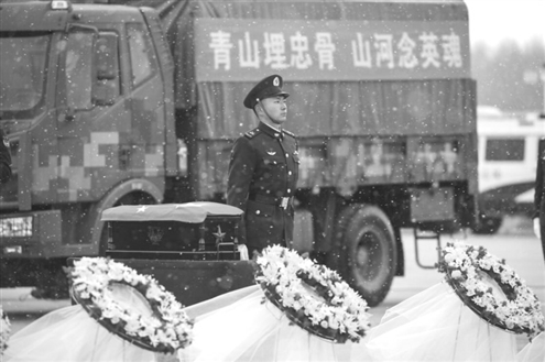 23日,在沈阳桃仙国际机场,礼兵将殓放志愿军烈士遗骸的棺椁从专机上护送至棺椁摆放区。